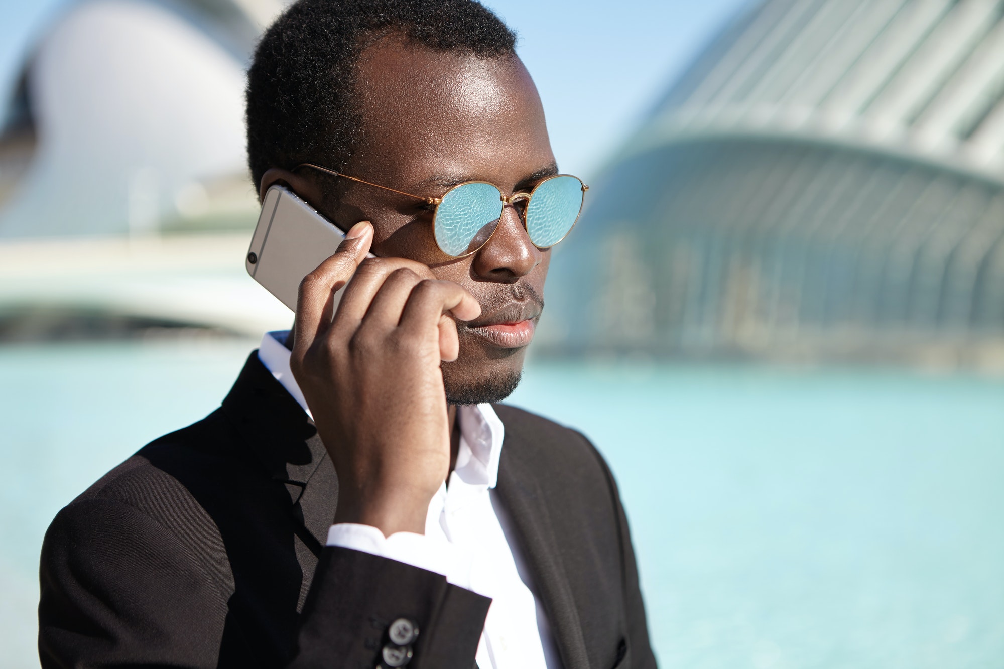 People, lifestyle, business and modern technology. Confident Afro American businessman wearing black